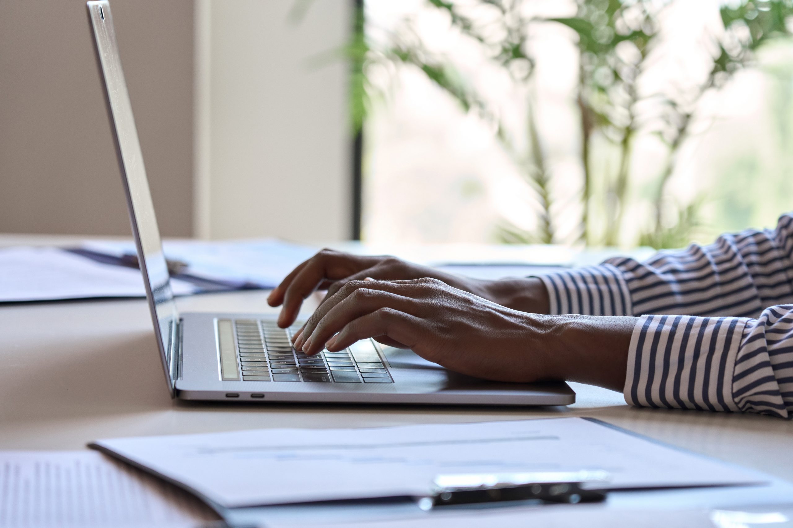 Young Black female hands typing on PC keyboard, African businesswoman.